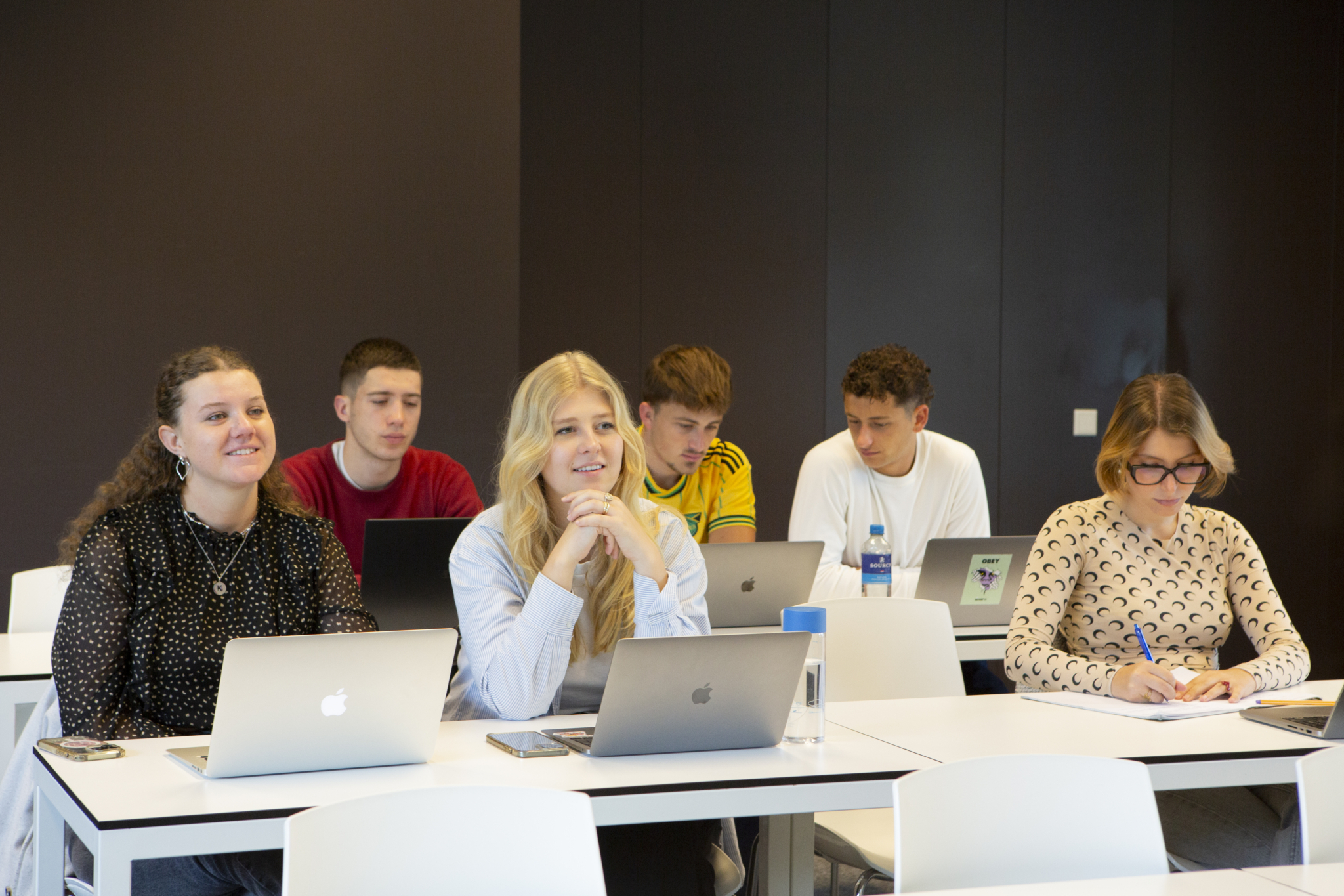 Happy students at the entrance of campus Amsterdam