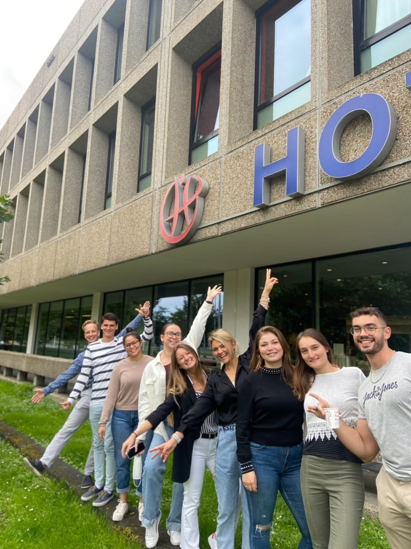 Happy students at the entrance of campus Amsterdam